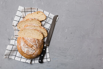 Freshly baked bread cut with knife on a wooden board. top view Sliced bread and knife