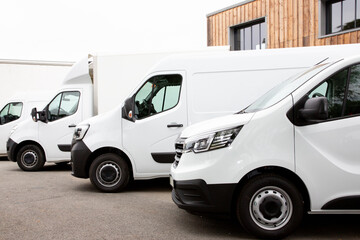 Wall Mural - Several cars vans trucks parked in parking lot for rent delivery white vans in service van truck front of entrance of warehouse distribution logistic society