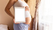 Pregnancy mockup digital tablet. Pregnant woman holding smart tablet. Mobile pregnancy online maternity application mock up. Concept maternity, pregnancy, childbirth.