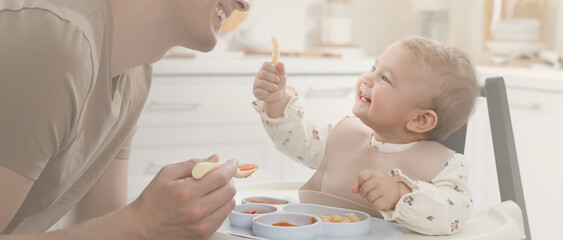 father feeding his cute little baby healthy food at home. banner design