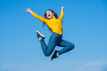 happy teen girl jumping on sky background