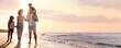 © New Africa - Happy family walking on sandy beach near sea at sunset, space for text. Banner design