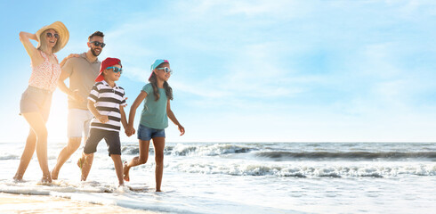 Canvas Print - Happy family running on sandy beach near sea, space for text. Banner design