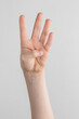 © Alexander - child hand counting and showing four fingers against white and gray background