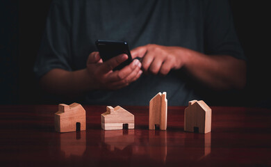 Wall Mural - Man using smartphone to Planning buy Real Estate, Planning to buy property investment and house mortgage financial concept.