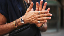 Close-up Of Male Hands In Bracelets And Rings. Man Adjusts The Ring On His Finger. Guy Twists The Ring On His Finger