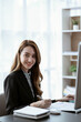 © Kritdanai - Asian businesswoman in formal suit in office happy and cheerful during using smartphone and working