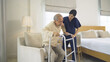 Asian woman nurse, daughter help father to get up from chair, supporting old senior elderly patient in bedroom in home or house in medical and healthcare. People lifestyle. Family disability therapy.