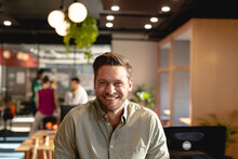 Portrait Of Smiling Caucasian Young Businessman In Creative Office
