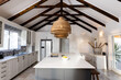 Lighting equipment hanging in a row from mansard roof over kitchen island in modern kitchen