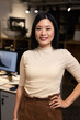 © Wavebreak Media - Portrait of smiling asian female professional with hand on hip standing in modern office at night