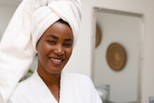 Close-up Portrait Of Smiling Young African American Woman Wearing Head Towel In Bathroom At Home