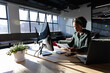 © WavebreakMediaMicro - African american young businesswoman examining documents while sitting at computer desk in office
