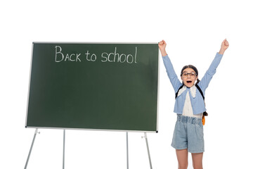 Canvas Print - Excited pupil showing yes gesture near chalkboard with back to school lettering isolated on white.