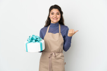 Wall Mural - Pastry Russian chef holding a big cake isolated on white background pointing to the side to present a product