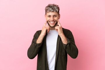 Canvas Print - Young handsome caucasian man isolated on pink background smiling with a happy and pleasant expression