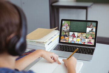 Poster - caucasian boy writing maths problems while studying online over video call on laptop at home
