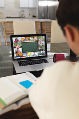 Sticker - Asian boy with books on table attending online lecture over video call on laptop at home