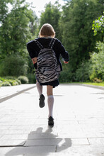 A Running Girl In A School Uniform And A School Bag From The Back.
