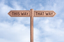 This Way Or That Way Concept. Words In Opposite Directions On Signpost With Sky Background