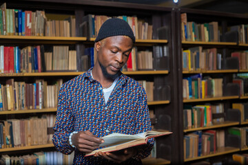 Wall Mural - close up of a handsome international student reading in the library