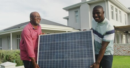 Wall Mural - video of two african american men carrying the solar panel