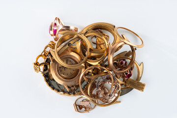 A scrap of gold. Old and broken jewelry, watches of gold and gold-plated on a white background.