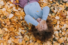 Cute Little Girl Laying On Yellow Leaves In Park At Fall Time, Autumn, Card, Banner, Healthy