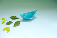 Clean Energy For Sea And Cargo Transportation And Travel And Sustainable Maritime Transport Concept. Paper Boat Emitting Fresh Green Leaves. 