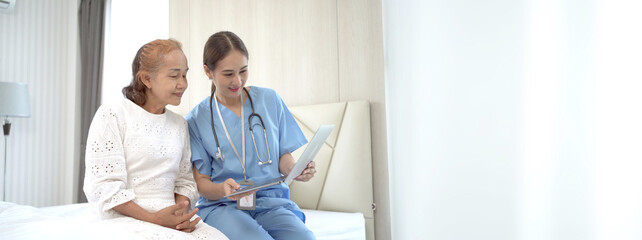 Female doctor comes to talk to elder patient in the hospital about the medical diagnosis. Doctor explaining a medical diagnostic result on laptop computer to old woman patient.