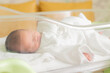© kimi - ベビーコットで寝ている新生児