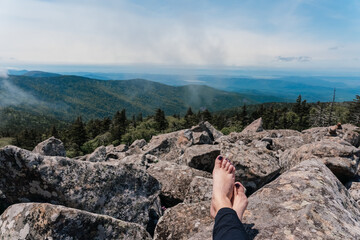 Legs of an unknown woman against the backdrop of a beautiful mountain view. Rest on the mountain