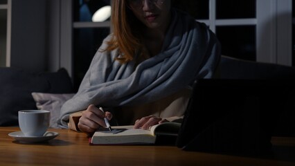 Asian businesswoman or freelancer working hard at the night looking the laptop digital tablet and document in workplace at late overtime deadline, Stressed busy and exhausted of work at home.