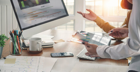 Cropped shot of business people working on graph and chart of business data information at office desk. using digital tablet.