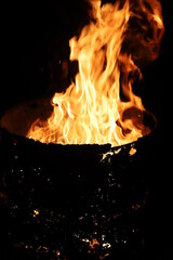 Fire in an oil tank in barrel, close-up on a dark background.