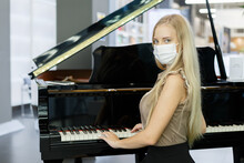 Portrait Of Young Woman Wearing Mask Playing Piano