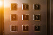 Inside modern metal elevator houses floor selection buttons with sunlight