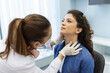 © Graphicroyalty - Endocrinologist examining throat of young woman in clinic. Women with thyroid gland test . Endocrinology, hormones and treatment. Inflammation of the sore throat