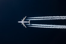 Low Angle View Of Airplane Flying Against Clear Blue Sky