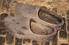 Enkhuizen, Netherlands. June 2022. Old Worn Clogs Against A Background Of Paving Stones.