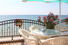 Cozy Veranda Next To The Beach With Wicker Furniture And An Umbrella. Nessebar, Bulgaria