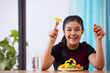 © IndiaPix - Portrait of girl eating healthy vegetable salad at home
