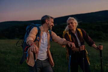 Mid adult couple hiking together out in the mountains