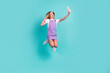 © deagreez - Full size photo of overjoyed carefree girl jump hold phone make selfie demonstrate v-sign isolated on teal color background