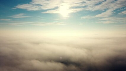 aerial drone view flight over fog. flight between white fluffy fog mist, clouds in blue sky and shin