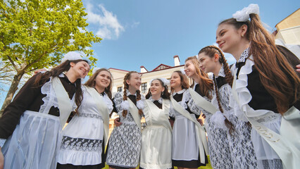 Wall Mural - Happy russian female graduates pose on their graduation day.