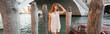 young woman in sleeveless jumper and shorts looking away near wooden pilings in Venice, banner.