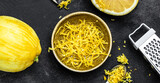 Fototapeta  - Yellow Organic lemons, zest and special tool. Grater peel and lemon zest on black background, banner, menu, recipe place for text, top view