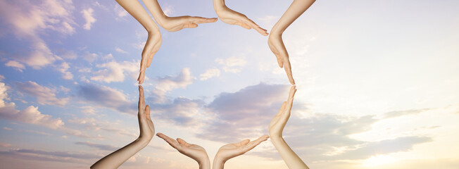 Hands on sky clouds. Unity,  support and togetherness concept