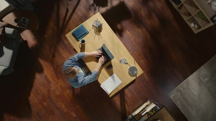 Aufkleber - Top View Static Shot Apartment: Freelance Entrepreneur Sitting at Desk Works on a Laptop.  Remote Access Professional Writes Emails, Manages Company Remotely Designs Software. Home Office Concept